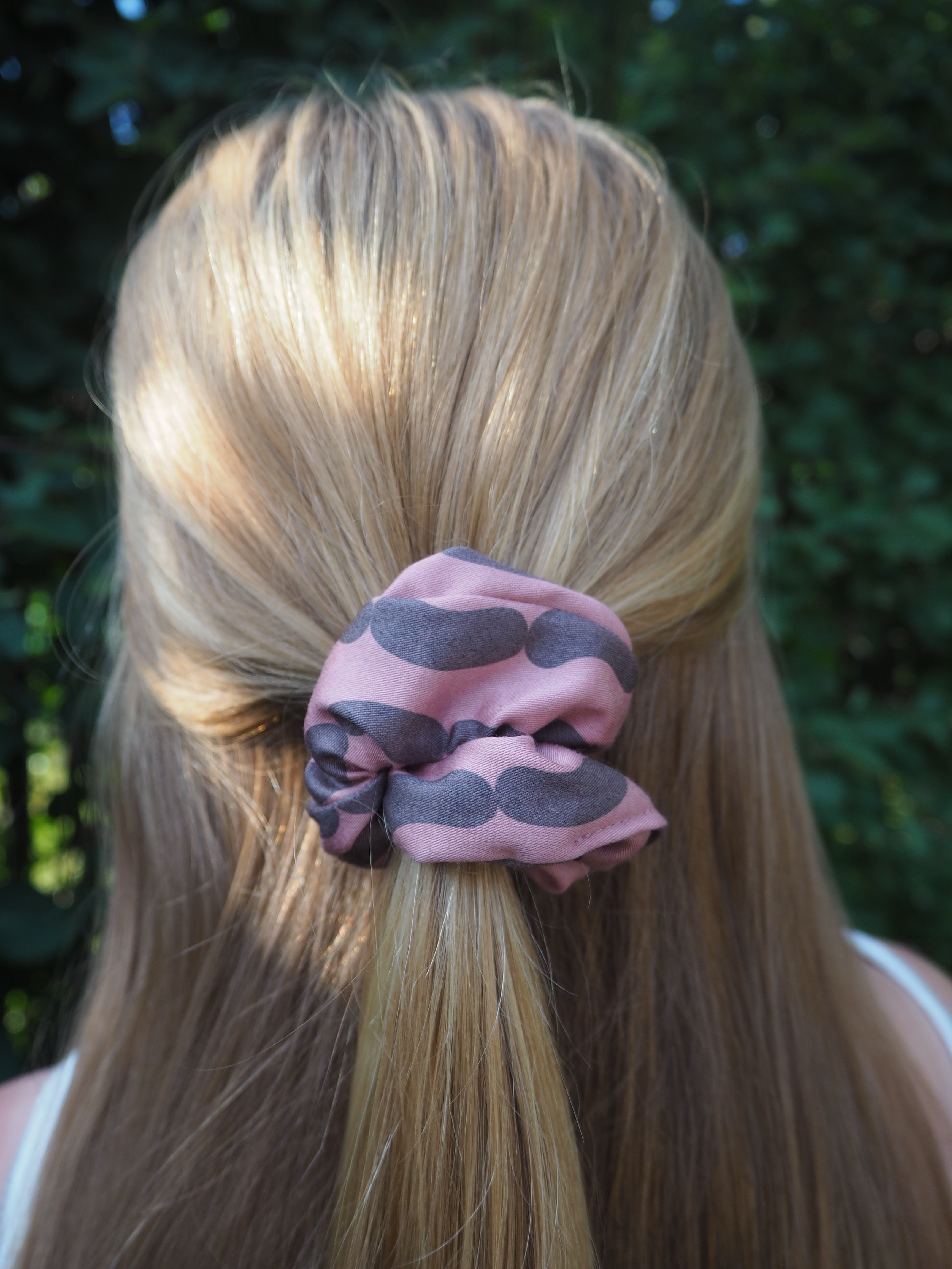 vaaleanpunainen hiusdonisti kierrätetysta kankaasta valmistettu makkararalli kuosi